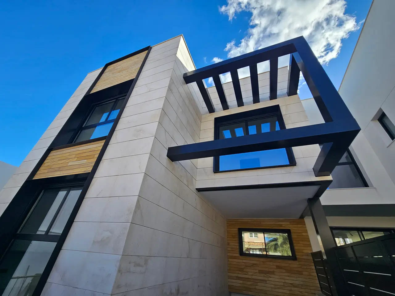 Viviendas pareadas con pérgola metálica, aplacado de piedra y madera