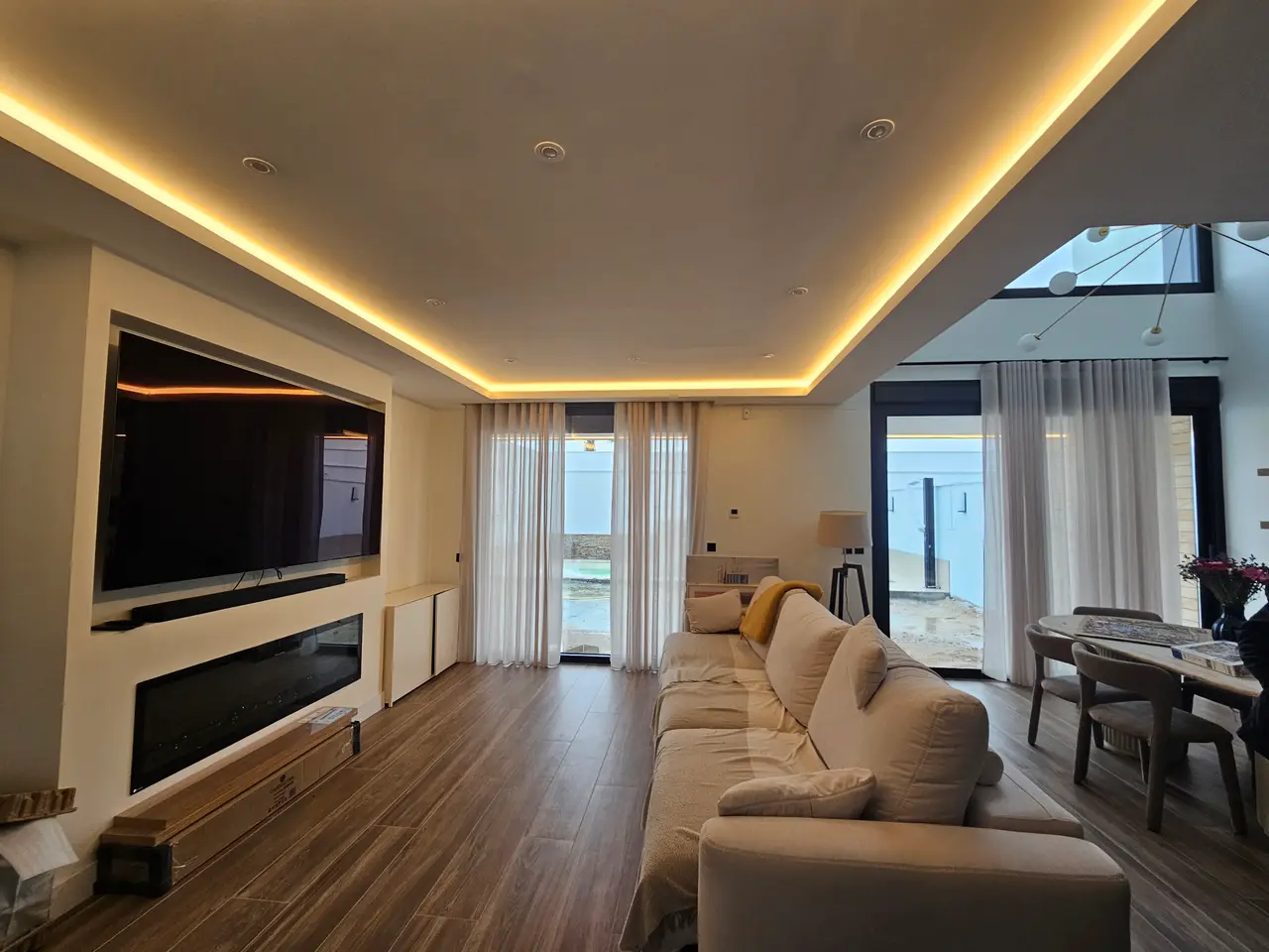 Salón de una vivienda unifamiliar terminada, con iluminación indirecta en el techo