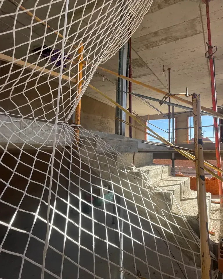 Red de seguridad colocada en el hueco de una escalera de vivienda en obra